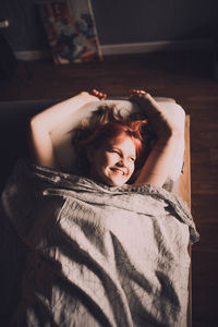 Portrait of young woman lying on bed at home