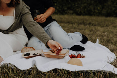 Low section of woman sitting on field