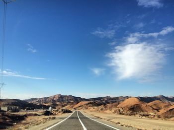 Road passing through landscape against sky