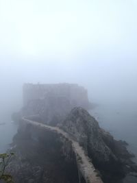 Scenic view of sea and mountains against sky