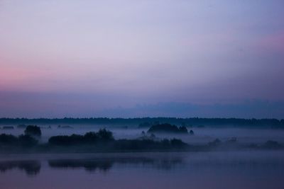 Scenic view of lake against sky at sunset