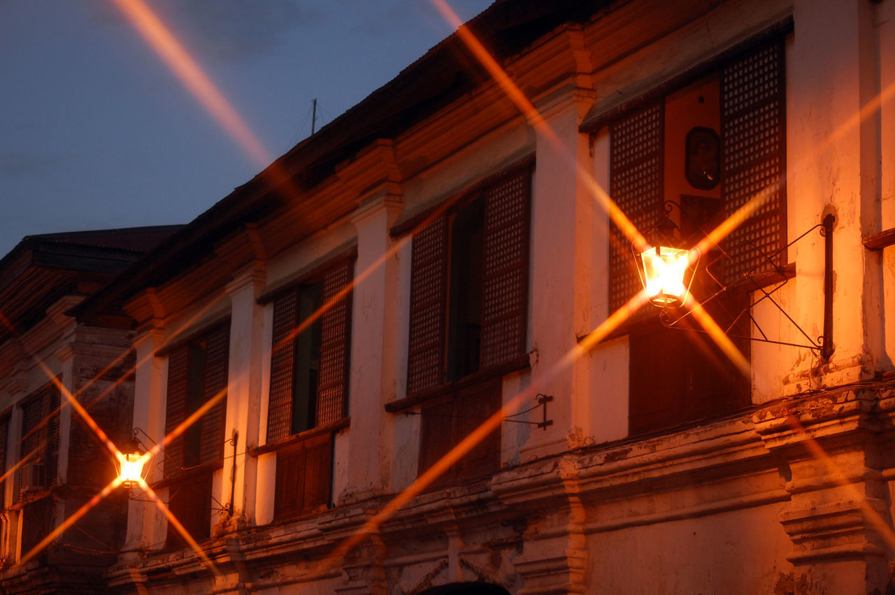 LOW ANGLE VIEW OF ILLUMINATED BUILDINGS AT NIGHT