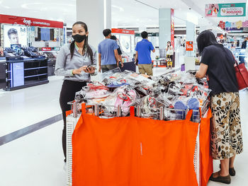 Rear view of people standing at store