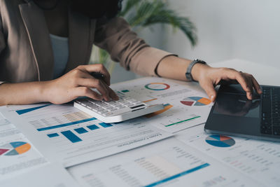 Midsection of business colleagues working on table