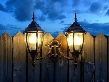 Close-up of illuminated lamp against sky