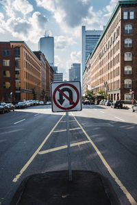 Road sign against buildings in city