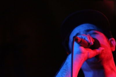 Low angle view of man singing against black background