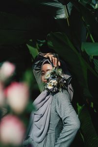 Portrait of woman standing by plants