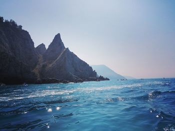 Scenic view of sea and mountains against sky