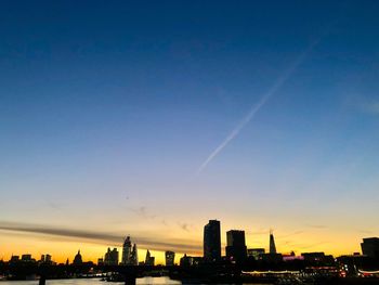 Silhouette buildings against sky during sunset