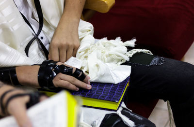 Midsection of man sitting with book