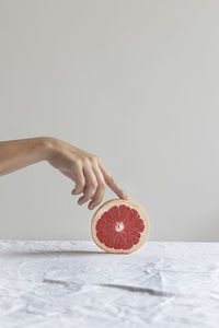 Midsection of woman holding apple against white background