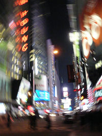 Blurred motion of illuminated street and buildings in city at night