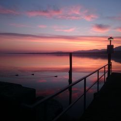 Pier on sea at sunset