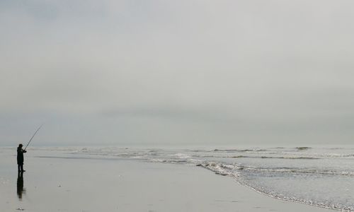 Fishing net on beach against sky