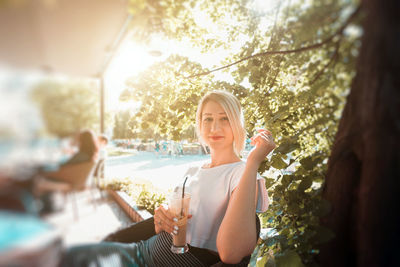 Portrait of a smiling young woman sitting outdoors