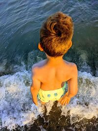 Young boy looks out into the open sea and imagines all that may come his way