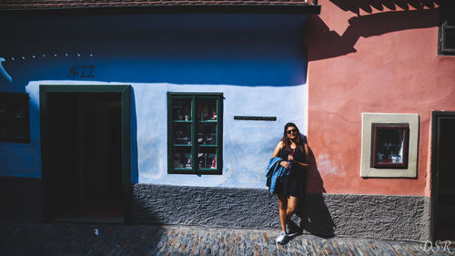 Full length of woman standing against building