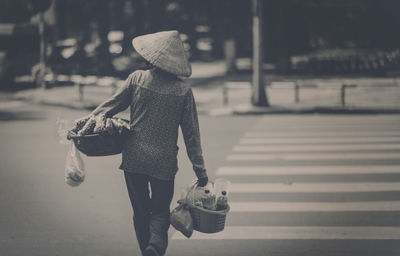 Rear view of woman crossing road