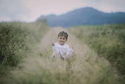 Portrait of young woman standing on field