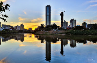 Reflection of buildings in lake during sunset