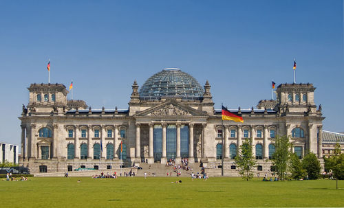 People in front of built structure against clear sky