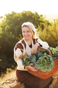 Portrait of a smiling young woman holding plant