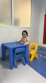 Portrait of cute girl standing by table