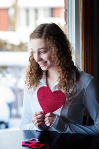 Young woman with cutout heart