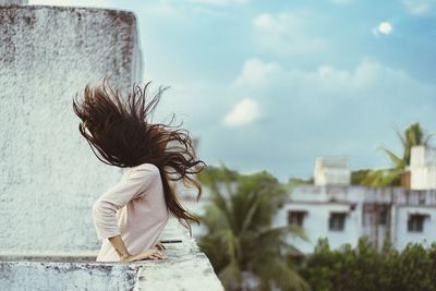 Young woman tossing hair on terrace