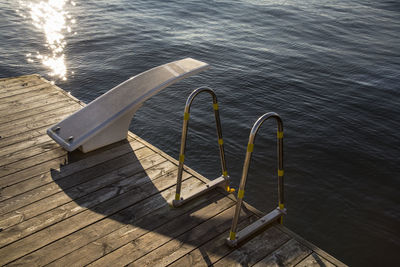 High angle view of railing by bollard on boardwalk by lake