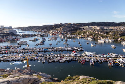 High angle view of people at harbor by buildings against sky