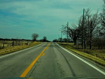 Empty road along trees