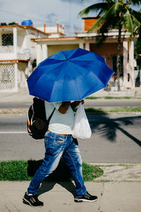 Man with umbrella walking on sidewalk