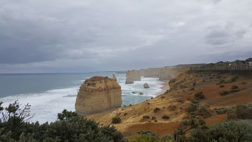 Scenic view of beach against cloudy sky