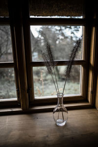 Close-up of glass vase on window sill at home