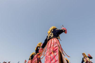 Low angle view of flags against clear blue sky