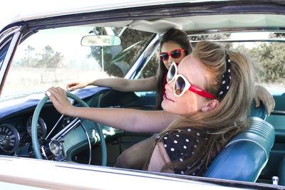 Smiling young friends sitting car