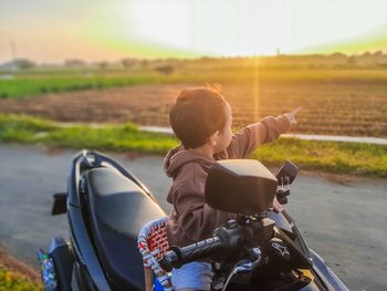 Rear view of man riding motorcycle on road