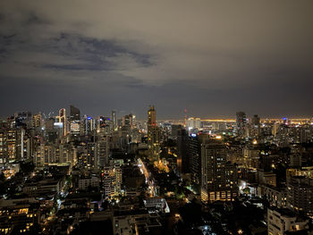 Illuminated cityscape against sky at night