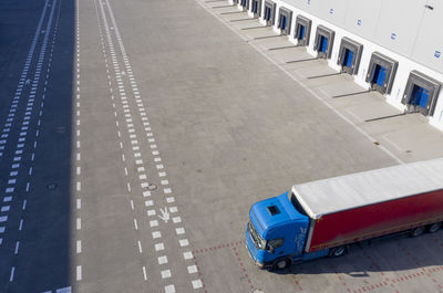 Aerial shot of industrial warehouse loading dock, truck with semi trailers load merchandise