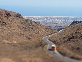 Scenic view of road by mountain against sky