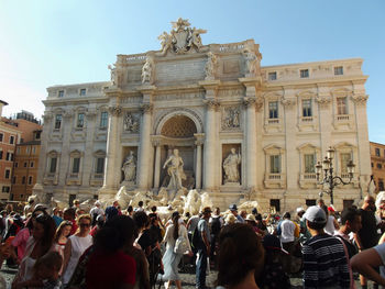 People by trevi fountain in city