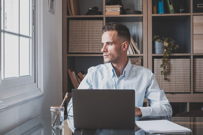 Young man using digital tablet while standing in office