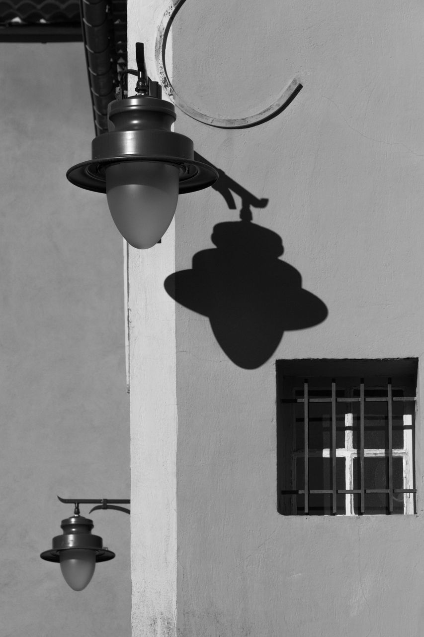 LOW ANGLE VIEW OF ILLUMINATED LIGHT BULB HANGING ON WALL