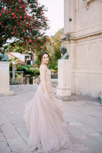 Woman standing against wall in city