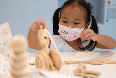 Cute girl wearing mask playing at home