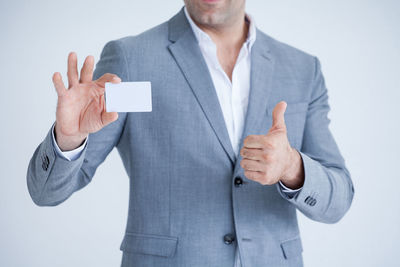 Midsection of man standing against white background