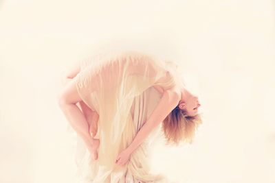 Side view of woman standing against white background