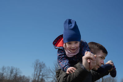 Father holding daughter on his shoulders. portrait of father and child outdoors. enjoying the moment